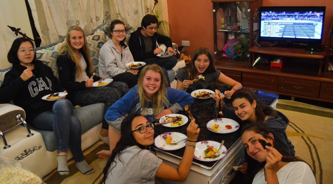 Volunteers eat together in their shared accommodation after a day of hard work